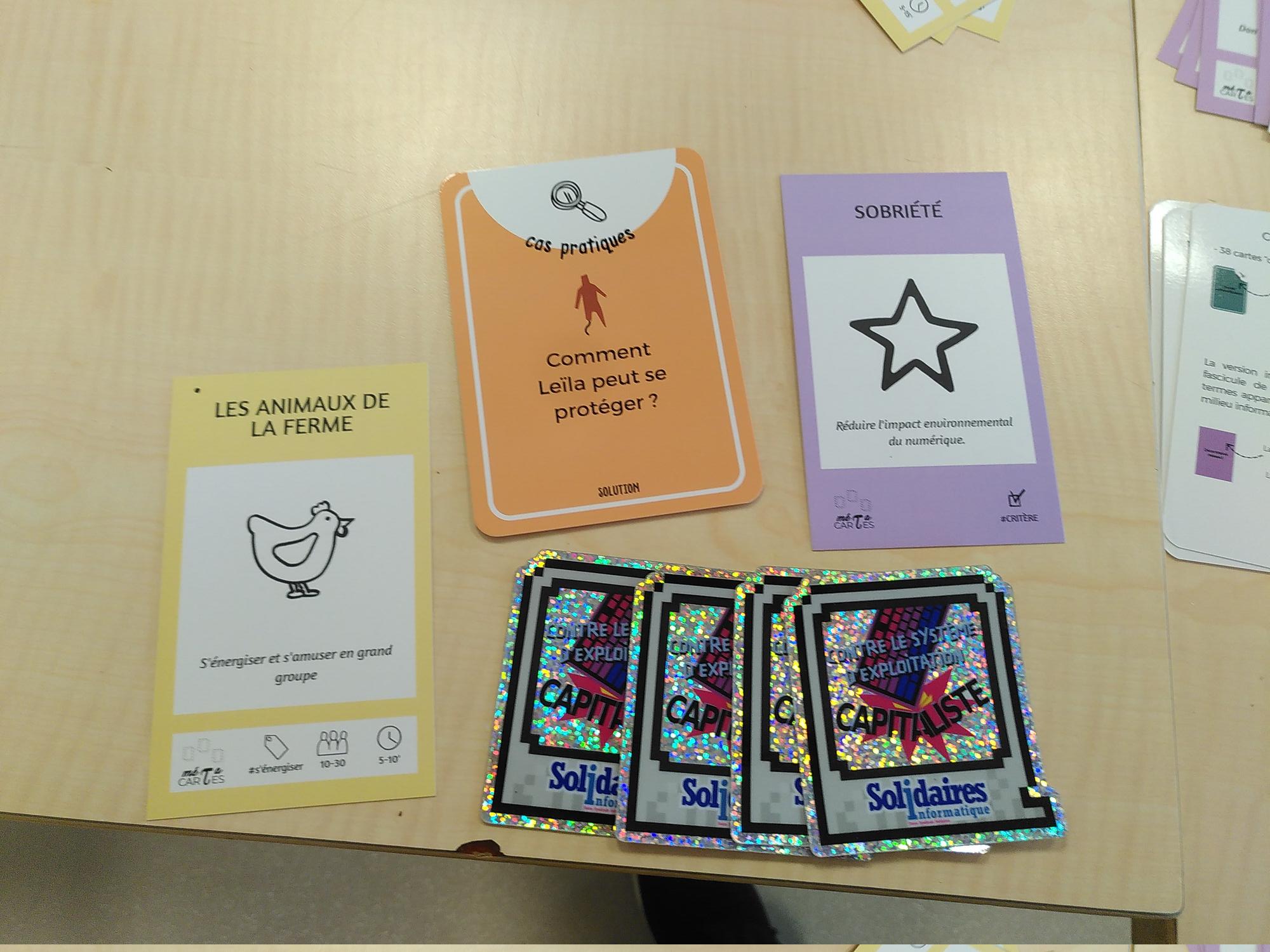 Quelques cartes de jeux différents sur lesquels il est écrit : Sobriété, Animaux de la ferme, Comment Leila peut se protéger, Solidaires - Contre le système d'exploitation capitaliste